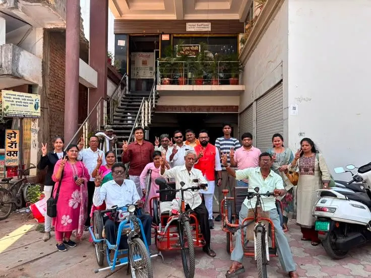 Group photo of volunteers and recipients with mobility aid tricycles distributed by the group