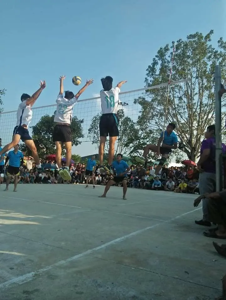 Players leaping at the net during a group-sponsored volleyball match